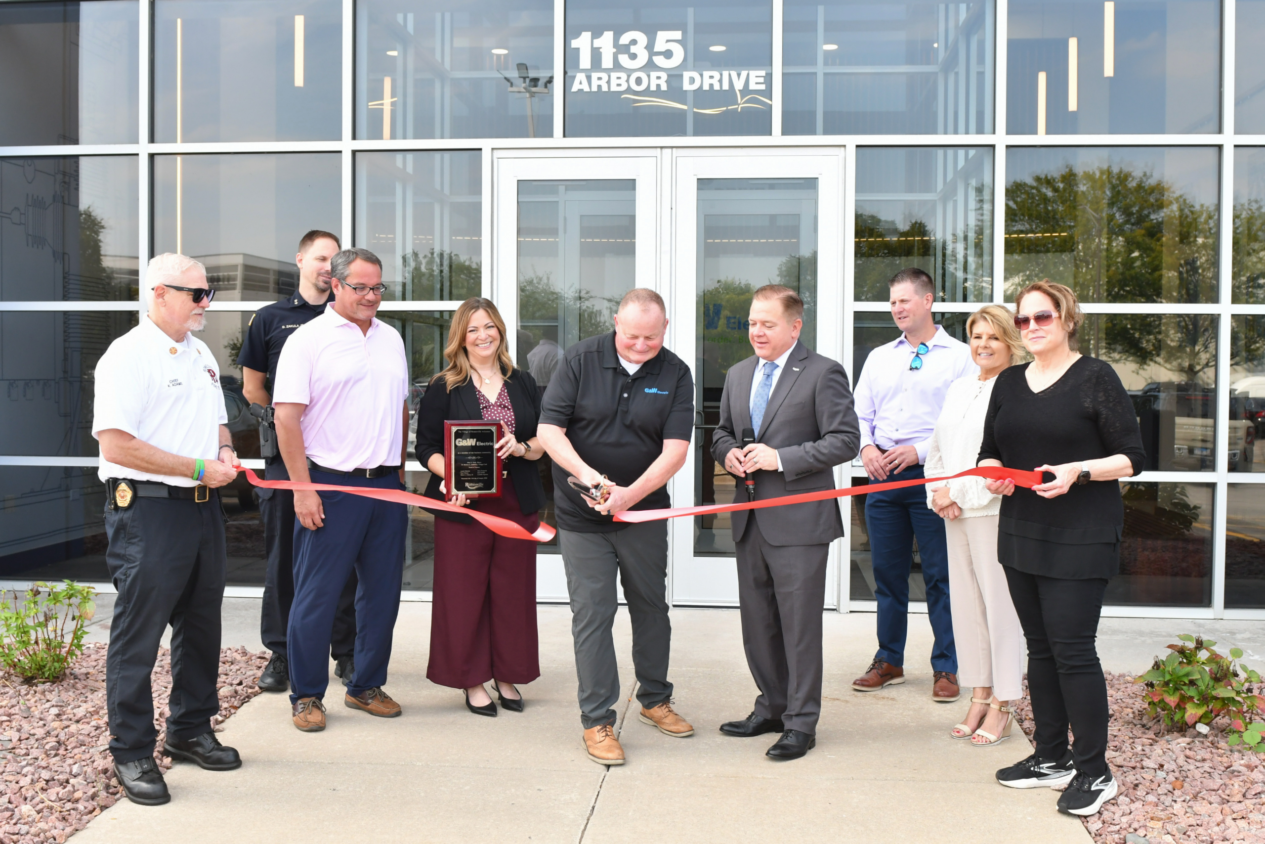 Ribbon cutting ceremony in front of the new 1135 G&W Electric building